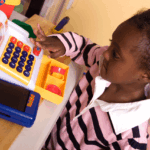 Child playing with a toy cash register