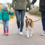 Family walking with dog on leash on path