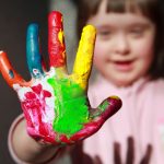 child with paint on hand