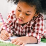 child writing with a pencil