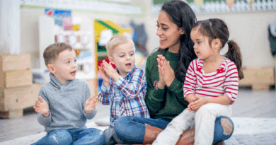 Teacher clapping with children on the floor