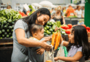 Mother and children choosing vegetables at the grocery store