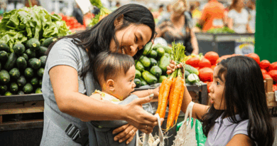 Mother and children choosing vegetables at the grocery store