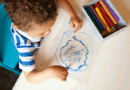Topview of a toddler scribbling on a piece of paper