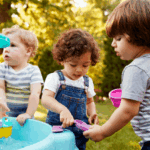 Toddlers play at a water table