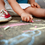 Child using chalk on the sidewalk
