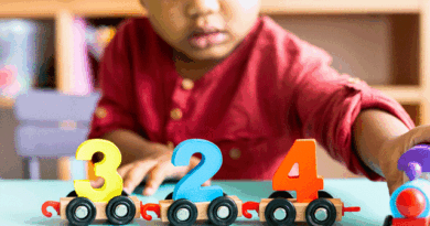 Toddler playing with cars with numbers on them