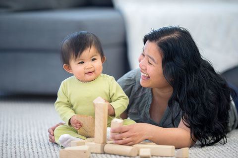 Mother building blocks with her baby