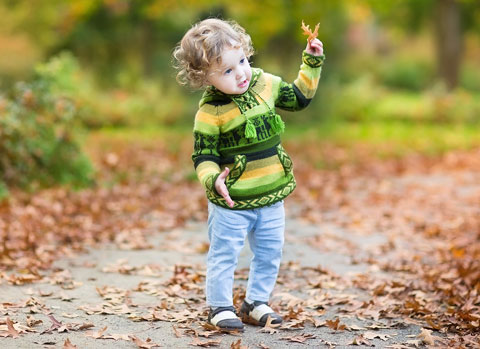child playing in leaves