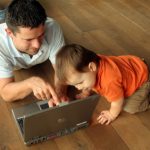 dad and child looking at laptop