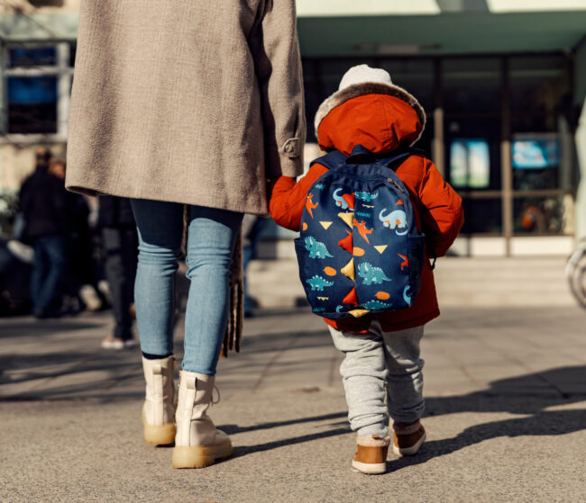 kindergarten child with adult and backpack