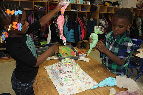 Figura 7. Utilizar varios dispositivos les ayudó a los niños a mejorar sus destrezas de motricidad fina al decorar el pastel de Abuelita Sandy. dma Sandy’s cake.