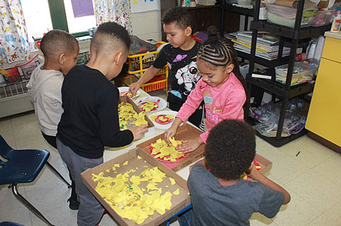 Figure 7. Children build pizzas to sell at their bakery and pizzeria.