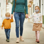 a parent walking with two children