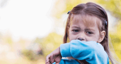Little girl covering her cough with her arm