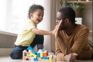 child and dad playing with blocks