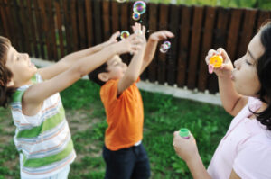 Happy children playing with bubbles