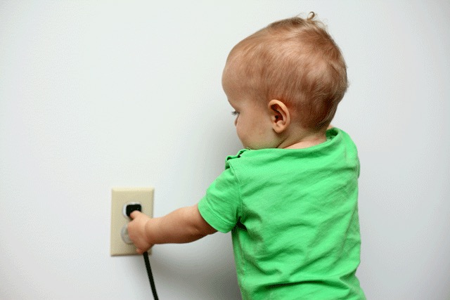 Child putting a cord in an outlet
