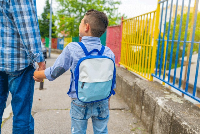 Father and son walking to school holding hands
