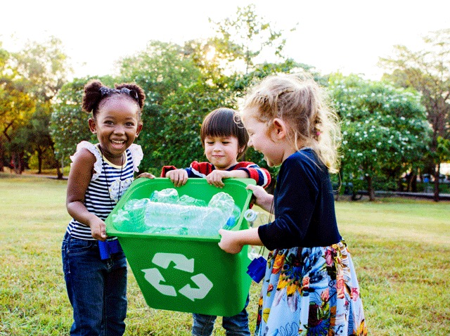 Children holding a recycling bin