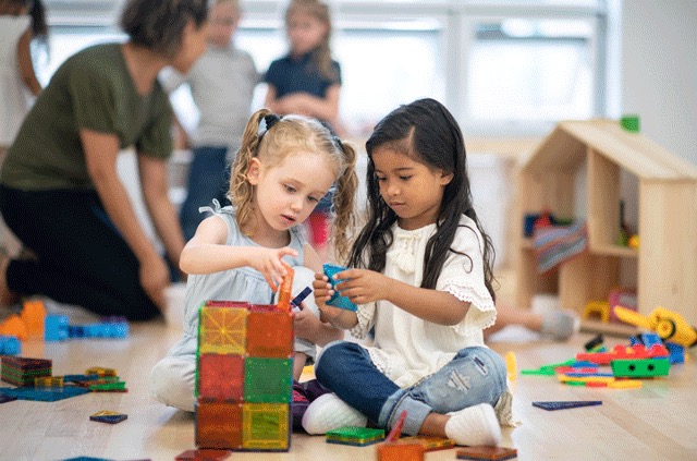 Two little girls playing with blocks
