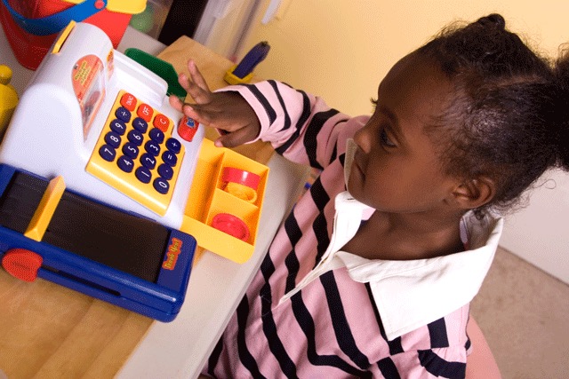 Child playing with a toy cash register