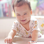 smiling baby in high chair