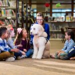 children sitting in circle at library with dog