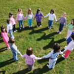 preschool children outside holding hands in a circle