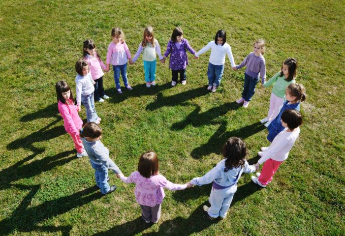 preschool children outside holding hands in a circle