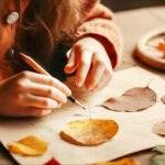 child drawing on paper while looking at leaves